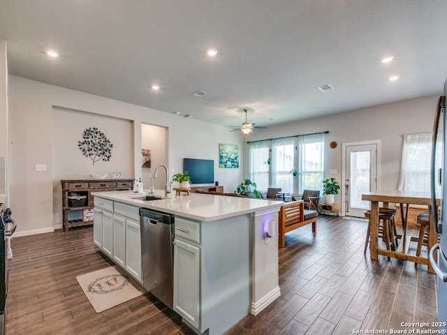 kitchen featuring dark wood-type flooring, dishwasher, a sink, and recessed lighting