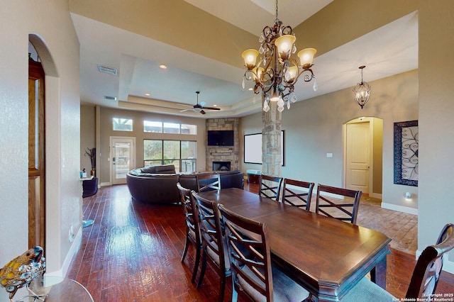 224 E Copper Trce, New Braunfels, TX 78132 - dining area with baseboards, a raised ceiling, arched walkways, a stone fireplace, and a ceiling fan
