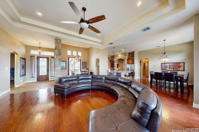 224 E Copper Trce, New Braunfels, TX 78132 - living area featuring baseboards, visible vents, a raised ceiling, arched walkways, and wood finished floors