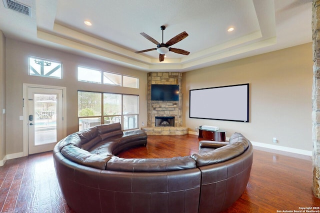 224 E Copper Trce, New Braunfels, TX 78132 - living room with ceiling fan, a tray ceiling, visible vents, a stone fireplace, and baseboards