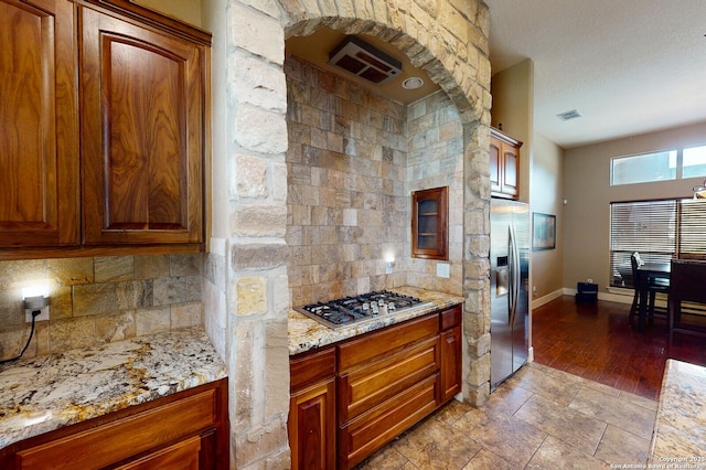224 E Copper Trce, New Braunfels, TX 78132 - kitchen featuring appliances with stainless steel finishes, a glass covered fireplace, backsplash, and visible vents