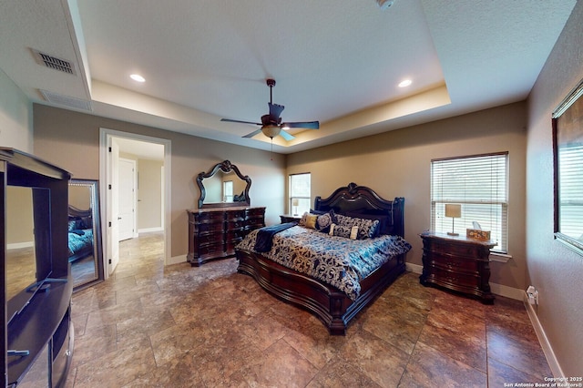 224 E Copper Trce, New Braunfels, TX 78132 - bedroom with a tray ceiling, stone finish flooring, baseboards, and visible vents