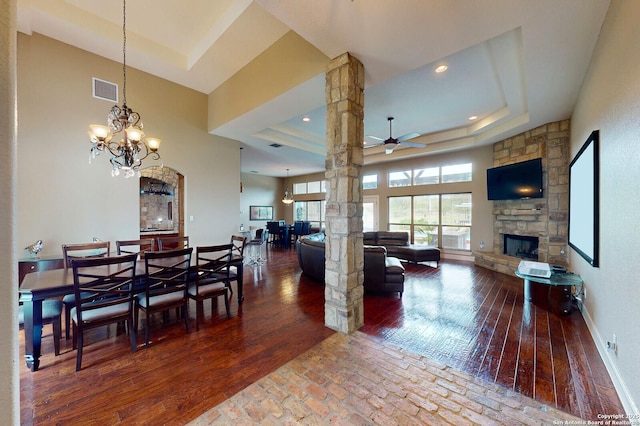 224 E Copper Trce, New Braunfels, TX 78132 - living room with ceiling fan with notable chandelier, a fireplace, a tray ceiling, visible vents, and hardwood / wood-style floors