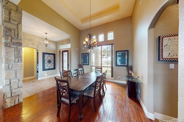 224 E Copper Trce, New Braunfels, TX 78132 - dining room featuring arched walkways, a notable chandelier, baseboards, and hardwood / wood-style floors