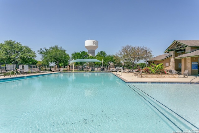 community pool with fence and a patio area