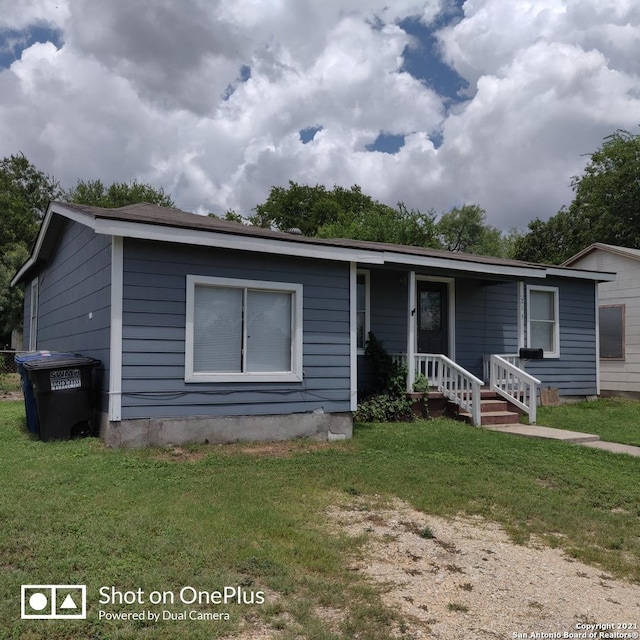 view of front of home featuring covered porch and a front lawn