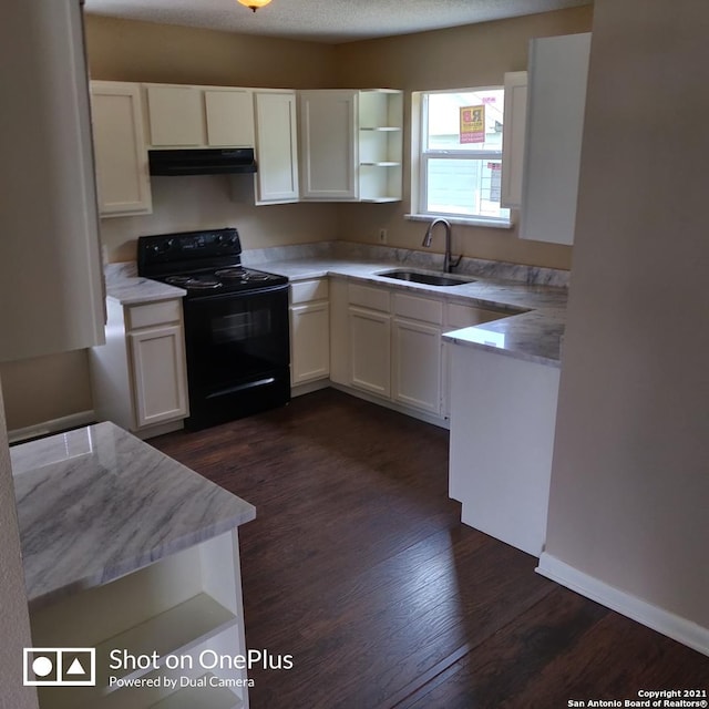 kitchen featuring electric range, white cabinets, under cabinet range hood, dark wood-type flooring, and a sink