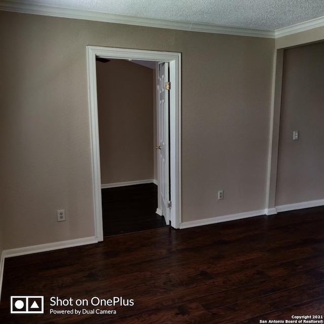 empty room with crown molding, baseboards, and wood finished floors