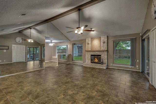 unfurnished living room featuring ceiling fan, baseboards, a stone fireplace, and a textured ceiling