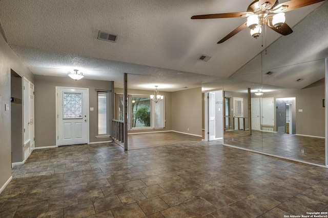 foyer entrance featuring baseboards, a chandelier, stone finish floors, a textured ceiling, and a ceiling fan