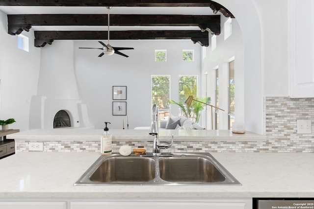 19211 Tierra Cv, San Antonio, TX 78258 - kitchen with ceiling fan, light stone countertops, a sink, decorative backsplash, and beam ceiling