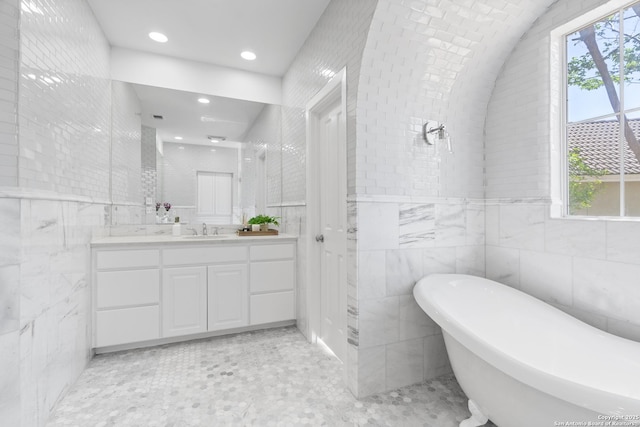 19211 Tierra Cv, San Antonio, TX 78258 - full bathroom featuring a soaking tub, vanity, recessed lighting, and tile walls