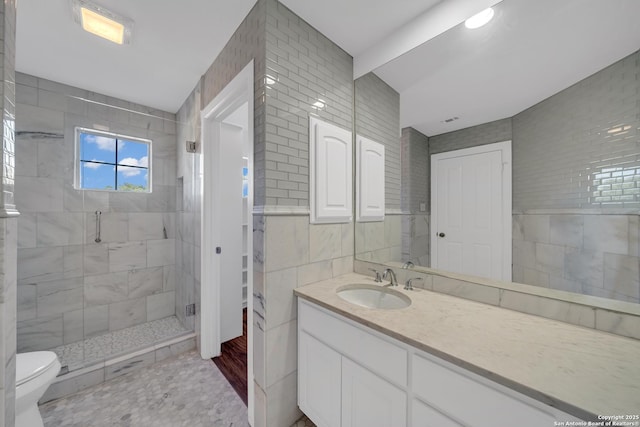 19211 Tierra Cv, San Antonio, TX 78258 - full bathroom featuring a shower stall, vanity, visible vents, toilet, and tile walls