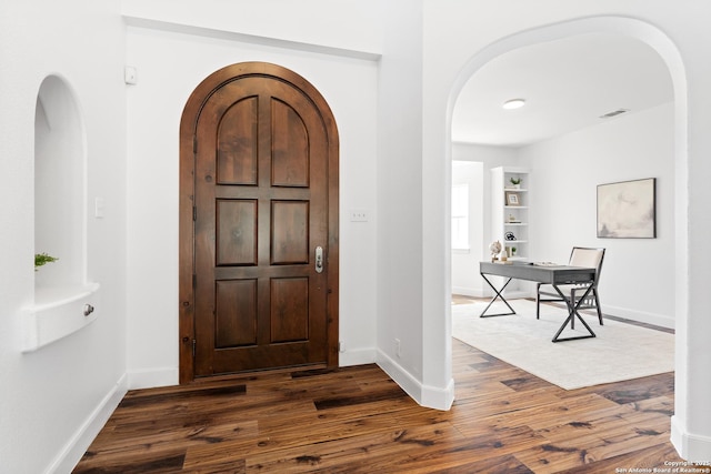 19211 Tierra Cv, San Antonio, TX 78258 - foyer entrance featuring arched walkways, dark wood-type flooring, visible vents, and baseboards