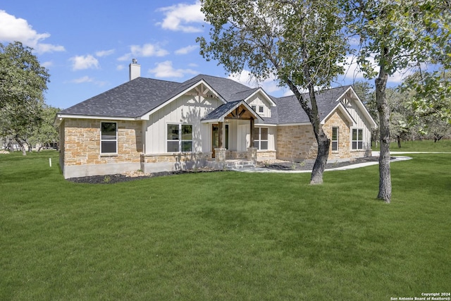 200 Bobby Lynn, Adkins, TX 78101 - view of front of house featuring stone siding, a chimney, and a front lawn