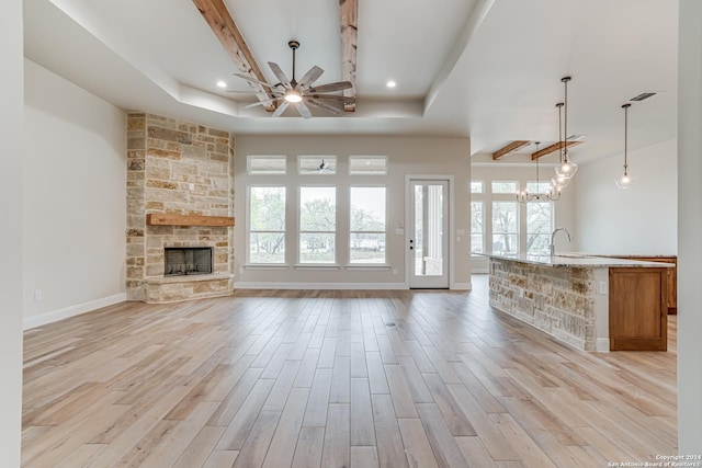 200 Bobby Lynn, Adkins, TX 78101 - unfurnished living room featuring a stone fireplace, a wealth of natural light, a ceiling fan, and light wood finished floors