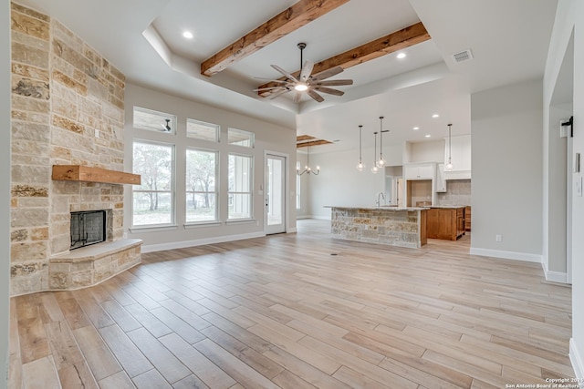 200 Bobby Lynn, Adkins, TX 78101 - unfurnished living room with light wood-type flooring, ceiling fan with notable chandelier, a fireplace, and visible vents