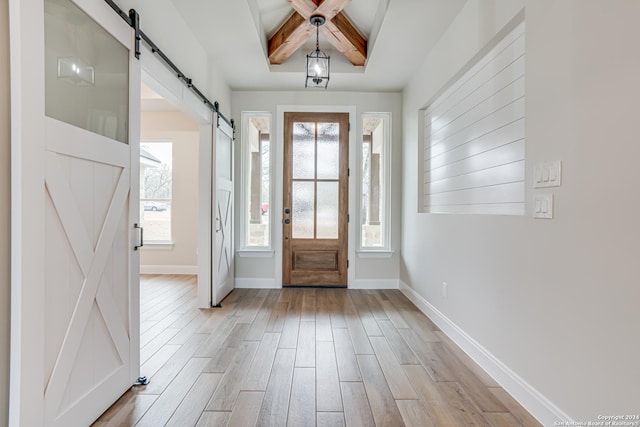 200 Bobby Lynn, Adkins, TX 78101 - foyer entrance with a barn door, light wood-style flooring, baseboards, and beam ceiling