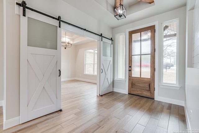 200 Bobby Lynn, Adkins, TX 78101 - foyer with a chandelier, light wood-style flooring, a barn door, and baseboards