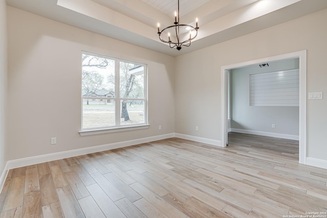 200 Bobby Lynn, Adkins, TX 78101 - unfurnished room with a raised ceiling, an inviting chandelier, baseboards, and light wood finished floors