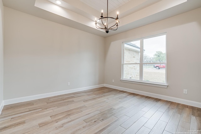 200 Bobby Lynn, Adkins, TX 78101 - spare room with baseboards, light wood-style flooring, a tray ceiling, and an inviting chandelier