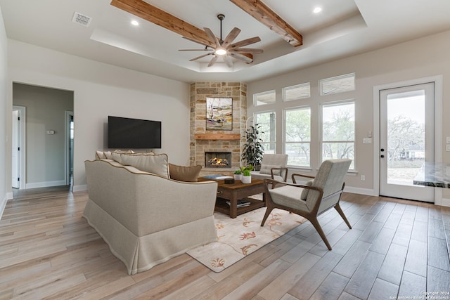 200 Bobby Lynn, Adkins, TX 78101 - living area featuring light wood-style floors, a stone fireplace, a ceiling fan, and visible vents