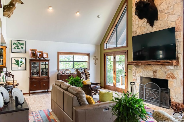 320 Overland Trl W, Hunt, TX 78024 - living room featuring a stone fireplace, light wood-type flooring, baseboards, and lofted ceiling