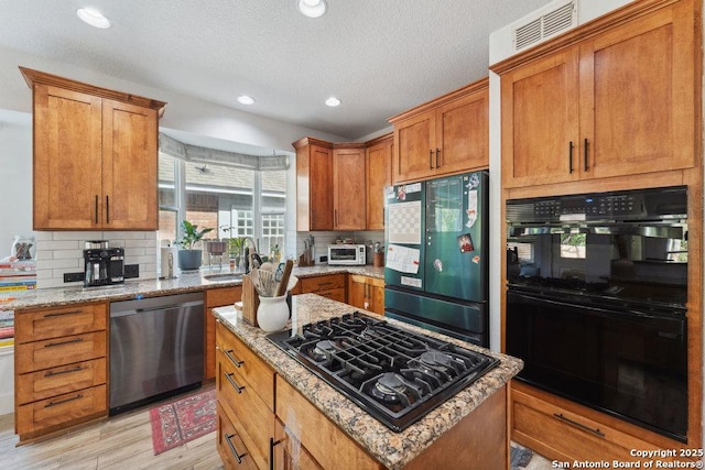2047 Thicket Trail Dr, San Antonio, TX 78248 - kitchen with brown cabinets, decorative backsplash, a sink, and black appliances