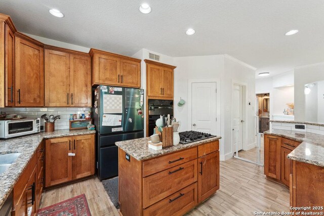 2047 Thicket Trail Dr, San Antonio, TX 78248 - kitchen featuring tasteful backsplash, a center island, freestanding refrigerator, light wood-style floors, and brown cabinets