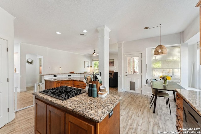 2047 Thicket Trail Dr, San Antonio, TX 78248 - kitchen with black gas stovetop, a center island, light wood finished floors, and brown cabinetry
