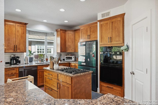 2047 Thicket Trail Dr, San Antonio, TX 78248 - kitchen featuring tasteful backsplash, a sink, brown cabinetry, black appliances, and light stone countertops
