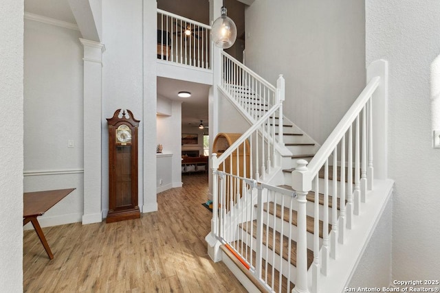 2047 Thicket Trail Dr, San Antonio, TX 78248 - stairs featuring crown molding, arched walkways, a high ceiling, wood finished floors, and baseboards