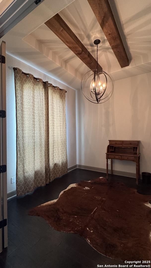 interior space featuring beamed ceiling and an inviting chandelier