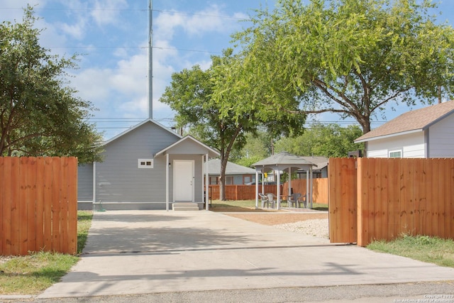 view of front facade featuring driveway, entry steps, and fence