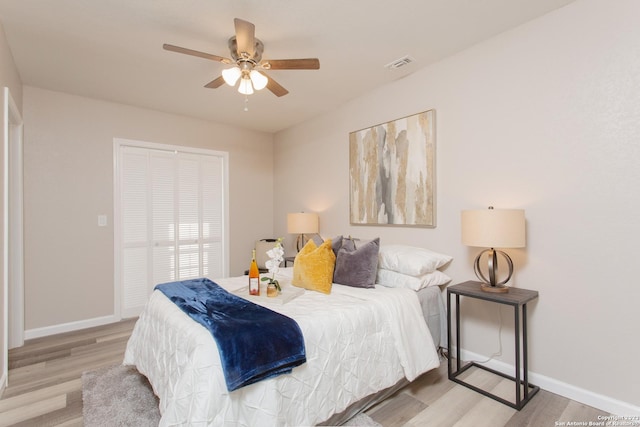 bedroom with visible vents, baseboards, a closet, and wood finished floors