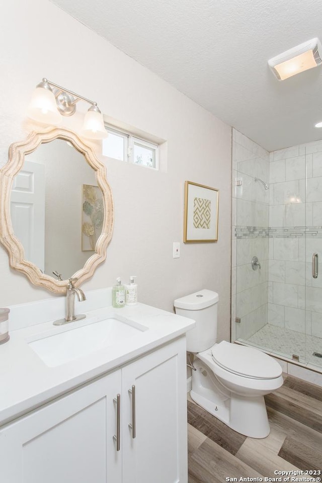 full bathroom with vanity, a stall shower, toilet, and wood finished floors