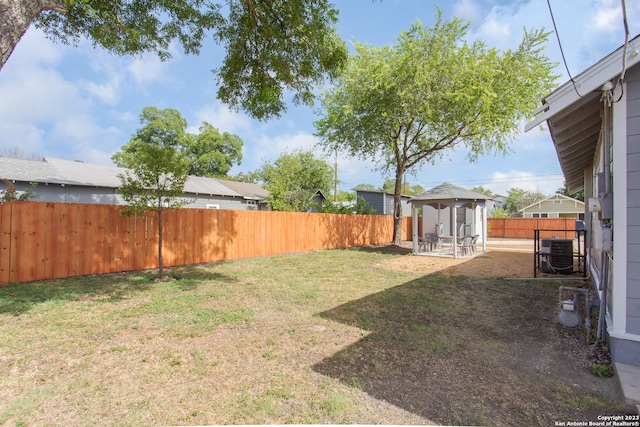 view of yard featuring a gazebo, a fenced backyard, central AC unit, and a patio area