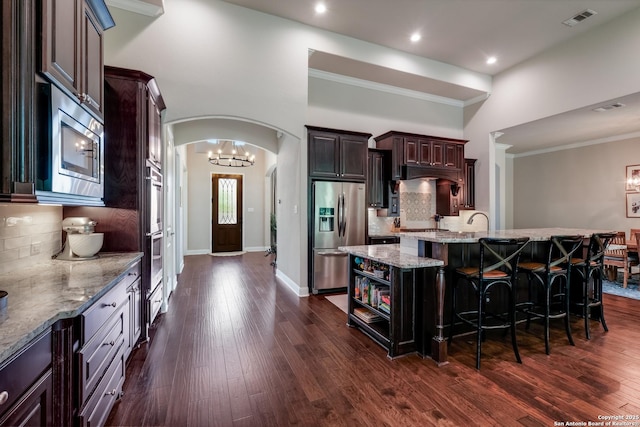 4111 Monteverde Run, San Antonio, TX 78261 - kitchen featuring visible vents, arched walkways, a kitchen bar, stainless steel appliances, and light stone counters