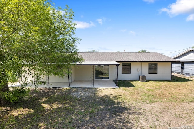 rear view of property featuring a patio area, a yard, and a shingled roof