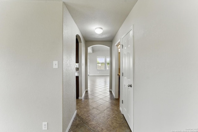 2441 Ibis, New Braunfels, TX 78130 - corridor featuring dark tile patterned flooring, baseboards, and arched walkways