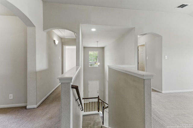 2441 Ibis, New Braunfels, TX 78130 - hallway featuring visible vents, baseboards, arched walkways, an upstairs landing, and carpet