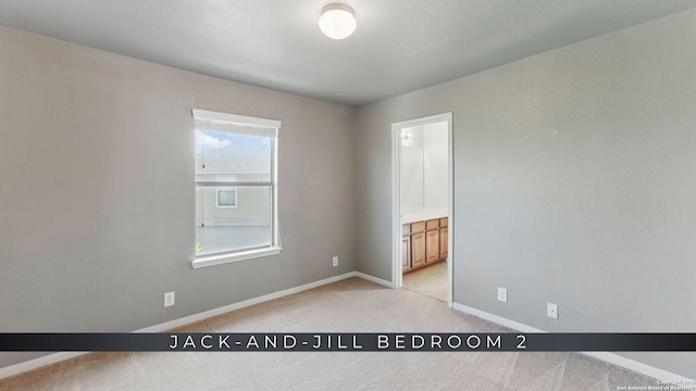 2441 Ibis, New Braunfels, TX 78130 - unfurnished bedroom featuring ensuite bath, light colored carpet, and baseboards
