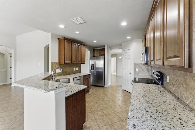 2441 Ibis, New Braunfels, TX 78130 - kitchen with arched walkways, appliances with stainless steel finishes, light tile patterned floors, and a peninsula