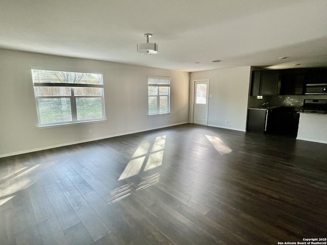 8131 Falcon Mdw, Converse, TX 78109 - unfurnished living room with baseboards and dark wood finished floors