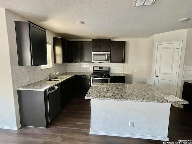 8131 Falcon Mdw, Converse, TX 78109 - kitchen with tasteful backsplash, visible vents, appliances with stainless steel finishes, dark wood-style floors, and a kitchen island