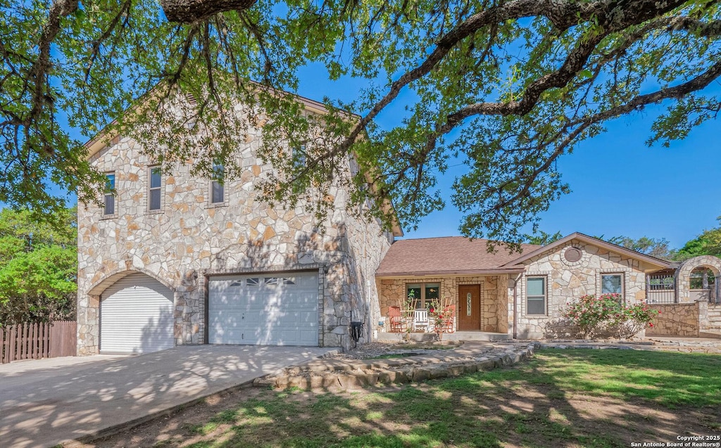 103 Walnut Way, Boerne, TX 78006 - view of front of home featuring a garage, covered porch, fence, stone siding, and driveway