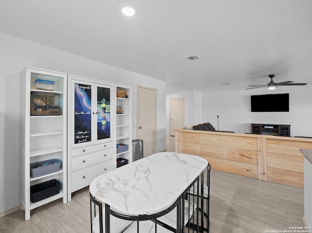 603 Vermilion, San Antonio, TX 78221 - kitchen with visible vents, light wood-style flooring, ceiling fan, and light stone counters