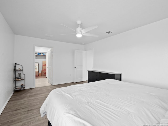 603 Vermilion, San Antonio, TX 78221 - bedroom featuring baseboards, connected bathroom, visible vents, ceiling fan, and wood finished floors