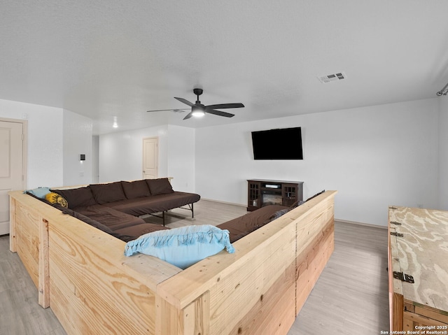 603 Vermilion, San Antonio, TX 78221 - living room with visible vents, ceiling fan, light wood-type flooring, and a fireplace