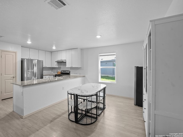 603 Vermilion, San Antonio, TX 78221 - kitchen with stainless steel appliances, visible vents, white cabinetry, and light wood-style flooring
